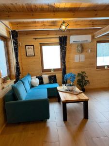 a living room with a blue couch and a table at Perła Kaszub in Wiele