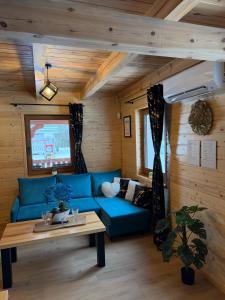 a living room with a blue couch and a table at Perła Kaszub in Wiele