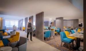 a rendering of a restaurant with tables and chairs at Maldron Hotel Parnell Square Dublin City in Dublin