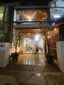 a hallway with two potted trees in a building at Homestay Lumina in Dong Hoi