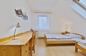 a bedroom with two beds and a wooden desk at Chalupa u golfu Kořenec in Kořenec +31 photos