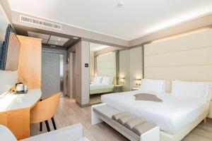 a bedroom with a large white bed and a desk at Park Hotel Ai Pini & Restaurant Ai Pini in Mestre