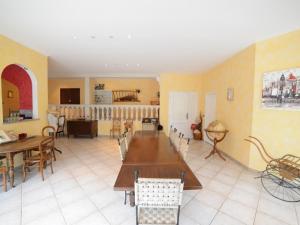 a living room with tables and chairs and a kitchen at VOIRIN Valérie in Cramant