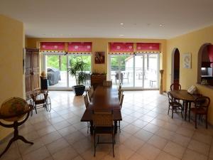 a living room with tables and chairs and a kitchen at VOIRIN Valérie in Cramant