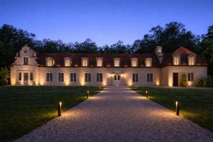 an estate with a pathway leading to a building with lights at Château de Vault de Lugny in Vault-de-Lugny