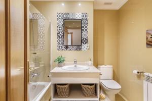 a bathroom with a sink and a toilet and a mirror at Sunny Beachside Escape by Minho's Guest in Póvoa de Varzim +17 photos