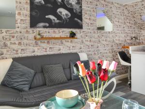 a living room with a gray couch and a brick wall at Holly's Apartment in Beverley