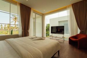 a bedroom with a large bed and a large window at PRAN MARE Pranburi in Ban Nong Ban Kao