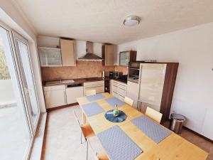 a kitchen with a wooden table and a kitchen with a table and chairs at Haus Groß Flöte in Wismar