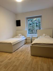 two beds in a room with a window at Haus Groß Flöte in Wismar