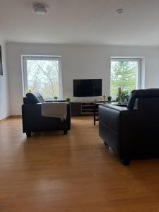 a living room with two couches and a flat screen tv at Haus Groß Flöte in Wismar