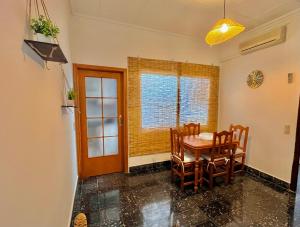 a dining room with a table and chairs and a window at Casa caloret -Playa y centro a 2 min - 1ªPlanta in Vinarós +5 photos