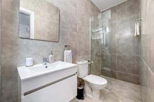 a bathroom with a toilet and a sink and a shower at Rons House in Paralimni