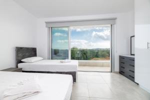a bedroom with two beds and a large window at Rons House in Paralimni