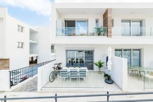 a house with a balcony with a table and chairs at Rons House in Paralimni