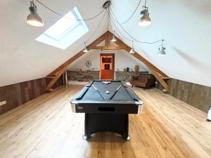 a room with a pool table in a attic at Le repaire Ardennais in Rossart