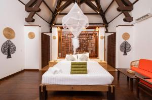 a bedroom with a white bed and a table at Kampung Kamboja in Phum Pobos