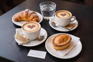 two cups of coffee and croissants on a table at Ai Raggi di Sole in Lecce