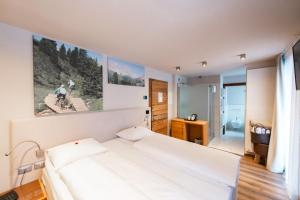 a bedroom with a white bed in a room at Chalet Vites Mountain Hotel in Canazei +84 photos