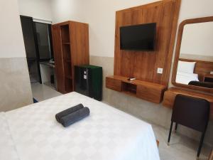 a room with a bed with a television and a bed sidx sidx sidx at Jepun Segara Guest House in Kuta