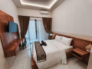 a hotel room with a bed and a television and a bed sidx sidx at Jepun Segara Guest House in Kuta +47 photos