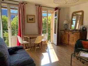 a living room with a couch and a table and chairs at T2 cosy centre ville in Luchon