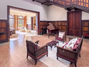a living room with chairs and a piano at Majordoms - Castell de Villavecchia - 33 pax in Sant Hilari Sacalm