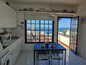 a kitchen with a table with chairs and a view of the ocean at Vista Mar Sardina in Gáldar