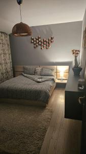 a bedroom with a bed and a table with a lamp at Râșnov Loft in Râşnov