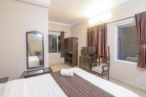 a hotel room with a bed and a mirror at Mounts shelts in Munnar