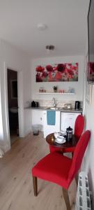 a red chair and a table in a room at The Snug in Naas