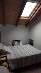 a bedroom with a large bed with a window at Casa Del Colle in Casasco +3 photos