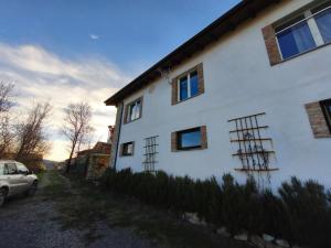 a white house with a car parked next to it at Casa Del Colle in Casasco