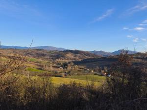 a view of a field with mountains in the background at Casa Del Colle in Casasco