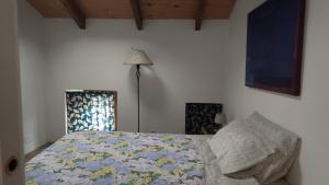 a bedroom with a bed and a lamp at Casa Del Colle in Casasco