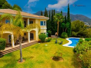 a house with a garden and a swimming pool at Diamante Villa Mijas in Mijas