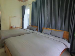 two beds sitting next to each other in a bedroom at Mây Villa Garden Đà Lạt in Xuan An +15 photos