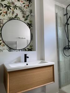 a bathroom with a sink and a mirror at T2 cosy centre ville in Luchon +14 photos