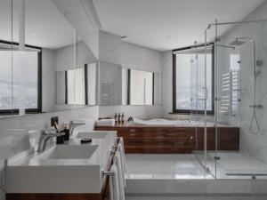 a bathroom with a tub and a sink and a shower at Kazakhstan Hotel in Almaty