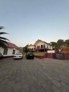 two cars parked in a parking lot in front of a house at WHITE FLOWER mountain resort in Perintalmanna