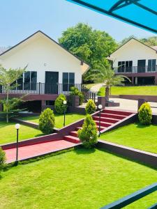 a house with a green yard with a red pathway at WHITE FLOWER mountain resort in Perintalmanna