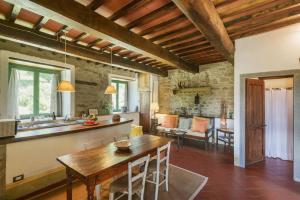a kitchen and living room with a wooden table at Romantic Apartment With Tuscan Valley Views in Londa