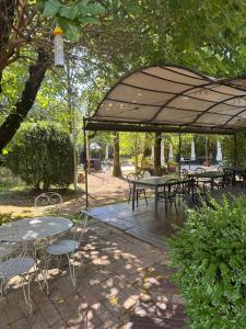 a wooden deck with tables and chairs under an umbrella at Agriturismo Aggazzotti in Colombaro