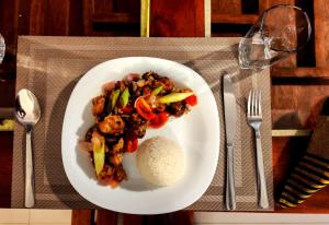 a plate of food with vegetables and rice on a table at Rainforest River Bay in Deniyaya +42 photos