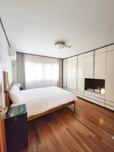 a bedroom with a large bed and a tv at Kintex Central Stay 3BR 2Bath Spacious Space in Ilsan-yŏk