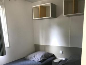 a bedroom with a bed and a mirror on the wall at Camping de Ceyreste - Maeva in La Ciotat +26 photos