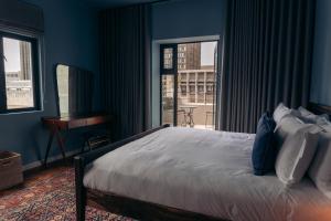 a bedroom with a bed with blue walls and a window at Gorgeous George by Design Hotels ™ in Cape Town +102 photos