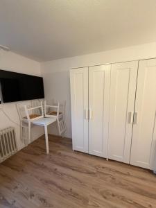 a room with white cabinets and a table and a desk at MELLoWY Monteure, TV, Küche, Bad in Gaggenau