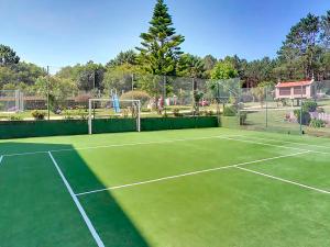 a tennis court with a tennis court at Hotel Mar del Norte 3000 in O Grove