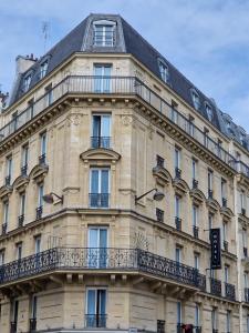 a building with a balcony on the side of it at Hotel André Latin in Paris